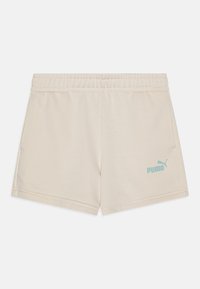 Shorts de color crema, hechos de una tela suave, que cuentan con una cinturilla elástica y un logo de Puma en azul claro en la parte inferior derecha.