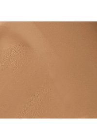 Texture de fond de teint liquide dans une teinte beige chaud, lisse avec une finition mate, présentant de fines particules se fondant parfaitement.