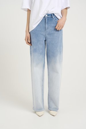 Jean taille haute large de couleur bleu clair avec une finition délavée. Le tissu semble en denim, arborant un design classique à cinq poches et des passants de ceinture.