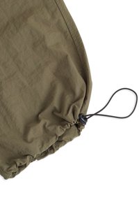 Olijfgroene lichtgewicht stof met een gestructureerd oppervlak. Voorzien van een cinched zoom met een zwarte trekkoord en toggle voor aanpassing.