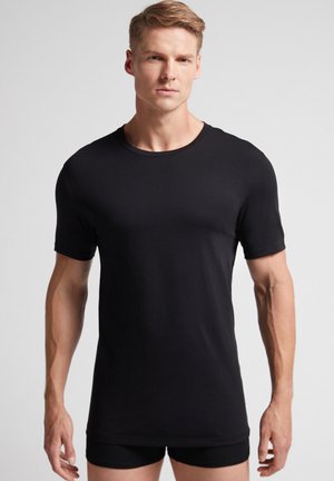 Schwarzes T-Shirt mit kurzen Ärmeln und Rundhalsausschnitt, aus glattem Stoff gefertigt. Verfügt über einen regulären Schnitt und minimalistisches Design.