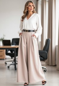 Biała bluzka z dekoltem w kształcie litery V i bufkami na rękawach, połączona z beżowymi spodniami o wysokim stanie, z plisami i czarnym paskiem z złotą klamrą.