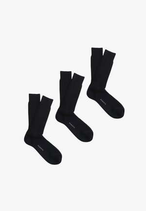 Calze nere a coste realizzate in materiale morbido, con un design a lunghezza media. Logo "PERofil" stampato sulla suola. Tre paia in esposizione.