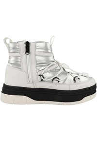 Zapatilla alta blanca y plateada con acentos metálicos, tela texturizada, sistema de cordones elásticos y suela negra gruesa. Cierre con cremallera en la parte posterior.