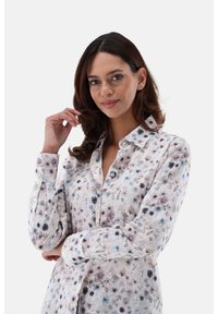 Bluse mit Blumenmuster aus leichtem Stoff, mit knöpfbarem Frontverschluss, langen Ärmeln und einer weichen Farbpalette mit blau- und lila Akzenten.