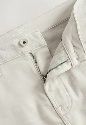Helle beige Slim-Fit-Hosen aus flexiblem Material; mit Reißverschluss, Knopfverschluss und gestickten Details im Taschenbereich.