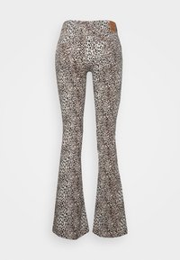Leggings largas com um padrão de estampado de leopardo em bege e preto, apresentando um tecido texturizado e um logo de couro castanho na cintura.