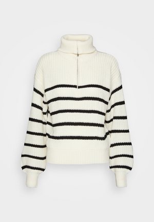 Pull en maille avec col montant en crème et rayures horizontales noires. Il dispose d'une fermeture éclair à demi sur le devant et de larges bords-côtes aux poignets et à l'ourlet.