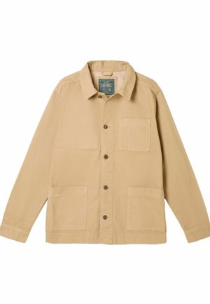 Veste en toile de couleur sable avec un col pointu, une fermeture à boutons sur le devant, deux poches plaquées inférieures et une poche poitrine. Présente une texture subtile.