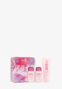 Zestaw pielęgnacji włosów Coco & Eve w przezroczystej torbie z zamkiem błyskawicznym, z różowymi i fioletowymi tropikalnymi wzorami. Zawiera dwie butelki i tubkę kremu.