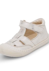 Sandale pour enfants en argent métallisé avec des bandages croisés, côtés ouverts et une semelle en caoutchouc texturé. Elle possède une sangle Velcro pour un maintien sûr.