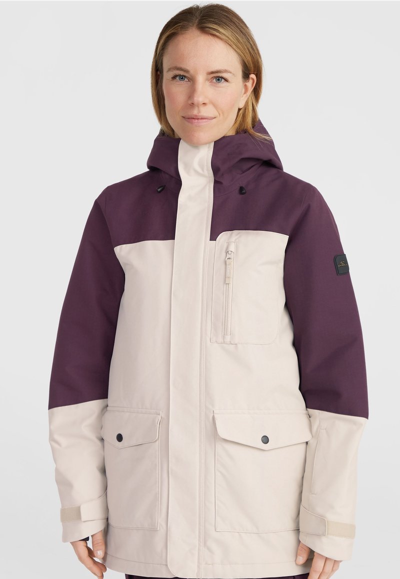 Lila und cremefarbene Kapuzenjacke mit einer Reißverschlusstasche, zwei vorderen Klappentaschen und verstellbaren Bündchen. Hergestellt aus strapazierfähigem, wetterfestem Material.
