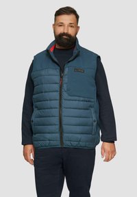 Gestepptes, dunkelblaues Weste mit Reißverschluss, hohem Kragen und einer Brusttasche. Verfügt über eine glatte Textur und Seitenknöpfe.