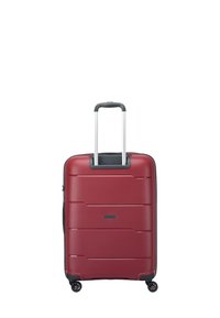 Maleta rígida roja con surcos verticales, asa retráctil y cuatro ruedas multidireccionales para una fácil maniobrabilidad.