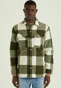 Groene en witte geruite flanellen shirt met twee borstzakken, drukknoopsluitingen en gebreide manchetten. Gemaakt van zachte, gestructureerde stof.