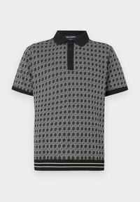 Polo preto e branco com padrão, gola, mangas curtas e punhos canelados. Apresenta um design geométrico distinto e uma pala com dois botões.