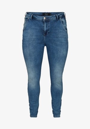 Niebieskie obcisłe dżinsy z przednimi kieszeniami, szlufkami na pasek, zapięciem na guziki oraz delikatnym przetarciem na udach i kolanach.