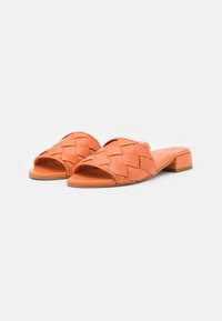 Woven orange leather slide sandals with an open toe, low block heel, and smooth sole. Features a braided pattern on the upper.