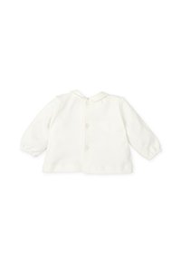 Chaqueta blanca para niño hecha de tela suave, con cuello, mangas largas y cierre de botones en la parte delantera. Diseño sencillo sin patrones.