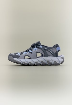 Grå og sort Merrell udendørs sandal med udskæringer, justerbare snørebånd og robust hvid sål på ensfarvet baggrund.
