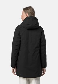 Giacca imbottita nera con cappuccio, finitura testurizzata, maniche lunghe e taglio leggermente allungato, caratterizzata da un design semplice e minimalista.