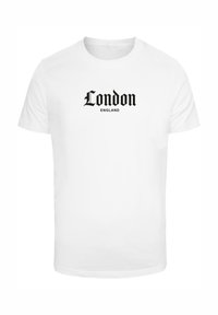 Balta medvilninė marškinėliai su juodu užrašu "London" ir "ENGLAND" ryškiu, stilizuotu šriftu. Trumpomis rankovėmis ir apvaliu iškirpimu.