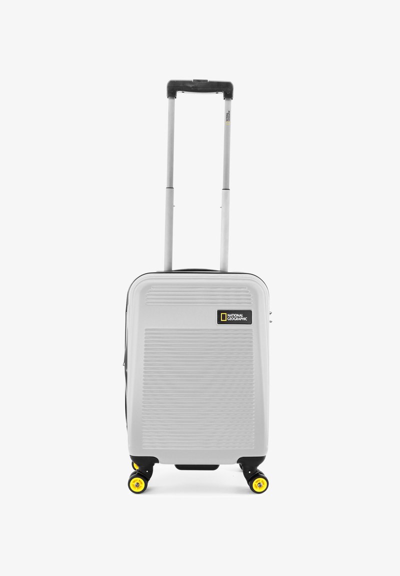 Gray hard-shell suitcase with vertical grooves, extendable handle, four yellow rotating wheels, and a National Geographic logo on the front.