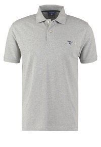 Polo à manches courtes gris clair avec deux boutons et petit logo sombre sur le côté gauche de la poitrine.