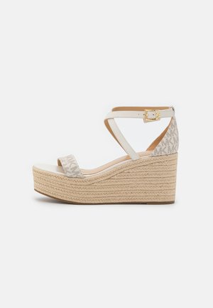 Sandale compensée espadrille avec plateforme tissée beige, lanières croisées beige autour de la cheville, motif logo MK sur le talon et fermeture à boucle dorée.
