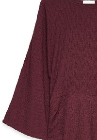 Burgundy huppari, jossa on teksturoitu kangas, löysä malli ja leveät hihat. Om lämmin kaula-aukko ja sauman yksityiskohtia alaosassa.