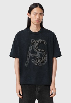Czarny oversize'owy t-shirt z fakturowanym wzorem łańcucha i ilustracją węża, z metalicznymi akcentami i okrągłym dekoltem.
