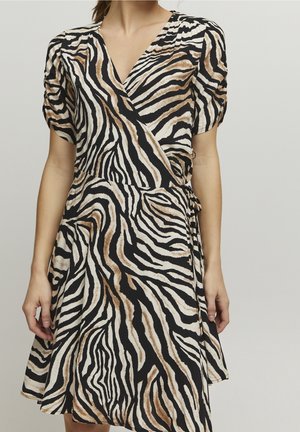 Viktdress i zebramönster med svarta, vita och bruna färger; har puffade korta ärmar och ett justerbart midjeband.