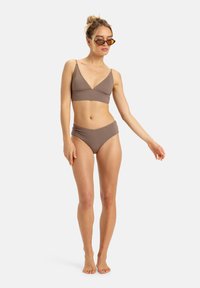 Bikini marrone a due pezzi con reggiseno triangolare e slip a vita alta. Tessuto morbido, design minimalista, spalline regolabili e senza decorazioni.