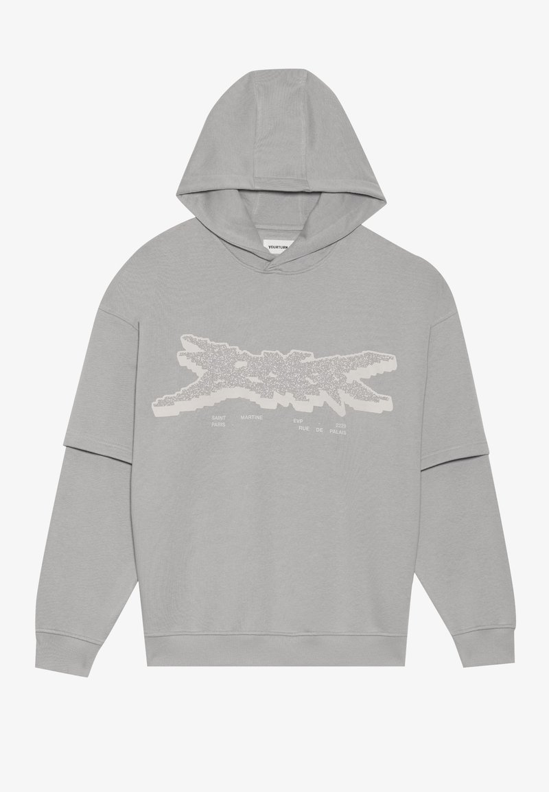 Sudadera gris claro hecha de algodón suave. Presenta un diseño gráfico frontal en texto blanco que asemeja una silueta. Mangas largas y una gran capucha.
