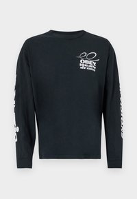 Schwarzes Langarm-T-Shirt aus Baumwolle mit Rundhalsausschnitt. Mit weißem Grafiktext und Logo auf der Brust und dem Ärmel. Glatte Textur, lockere Passform.