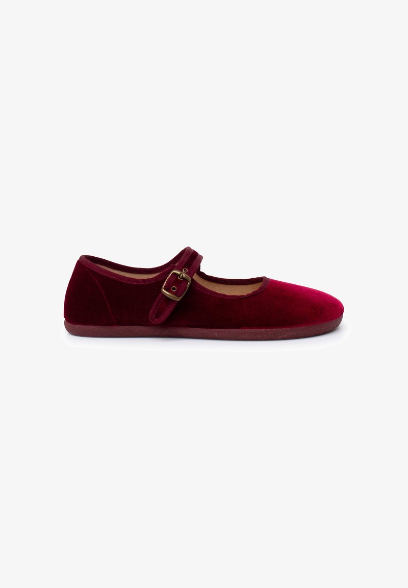 Zapato plano Mary Jane de terciopelo rojo, con punta redondeada, una tira de tela y un detalle de hebilla dorada. Textura suave y suela de perfil bajo.