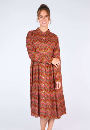 Langärmliges Hemdblusenkleid aus gemustertem Stoff mit Zickzacklinien in Rot-, Pink- und Grüntönen. Fließende A-Linie Silhouette.