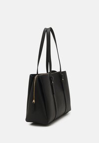 Sac fourre-tout en cuir noir au design structuré, avec deux longues poignées et une fermeture éclair dorée. Il présente une surface texturée et des accents minimalistes.