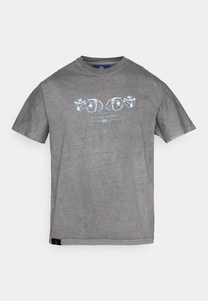 Harmaa puuvillapaita, jossa on pyöreä kaula-aukko ja lyhyet hihat. Keskellä on sininen graafinen printti renkaita ja teksti "HISTORIA TEKEJÄT".