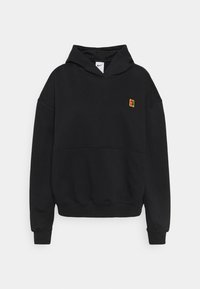 Schwarzer Kapuzenpullover aus weichem Material mit einer Fronttasche, gerippten Bündchen und einem Logo-Patch in Gelb und Rot auf der Brust.