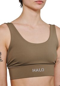 Olivengrøn sportstop lavet af glat, strækbart stof. Har en scoop-udskæring, brede stropper og "HALO" logo i hvidt på kanten.