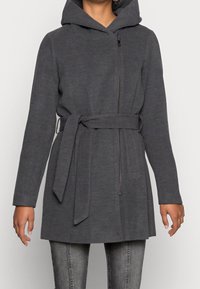 Abrigo gris con capucha, cierre de cremallera, cinturón ajustable y mangas largas, confeccionado en tela texturizada. Presenta un corte sencillo y recto.