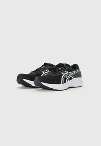 Baskets de sport noires avec un dessus en maille, accents blancs, bout arrondi et semelle en caoutchouc texturée pour l'adhérence. Lacets présents pour le maintien.
