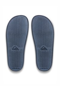 Kék gumi talpbetétek hullámos mintázattal és Quiksilver logóval, amelyek a kényelmet és a tapadást szolgálják. Simább élek és rugalmas forma.