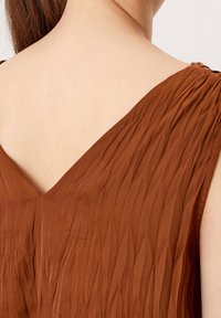 Brown pleated dress featuring a V-neckline, lightweight fabric, and soft texture. The design emphasizes vertical lines and a relaxed fit.