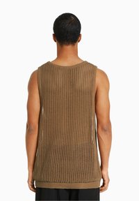 Top smanicato marrone lavorato a maglia con una texture leggera e ariosa e orlo a coste, che mostra un motivo a trama aperta sul retro.