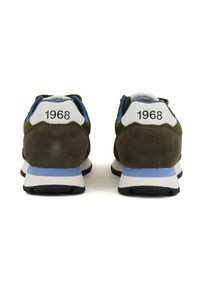 Green suede sneakers with white accents and blue details. Features a rounded shape and "1968" printed on the heel. Rubber outsole.