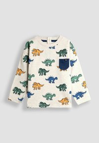 Krém színű, hosszmintás kisgyermek póló zöld, kék és narancssárga dinoszaurusz mintákkal, sötétkék melletti zsebbel, egyszínű háttéren.