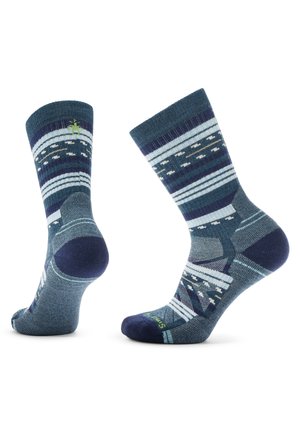 Calcetines de punto con un patrón geométrico en azul oscuro y verde azulado, con rayas y acentos. Tejido suave con detalles reforzados en la puntera y el talón.