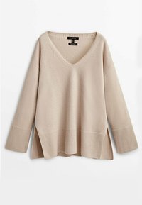 Beige gebreide trui met een V-hals, lange mouwen, geribbelde manchetten en zijslitsen aan de onderkant, met een zachte textuur en een relaxte pasvorm.